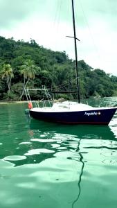 een boot in het water naast een strand bij Veleiro Alpha 22 Privativo in Paraty +35 foto's