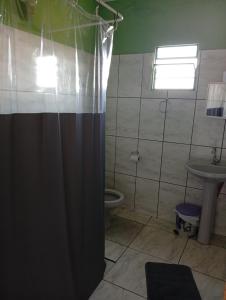 a bathroom with a shower with a toilet and a sink at Casa Pôr do Sol in São Thomé das Letras