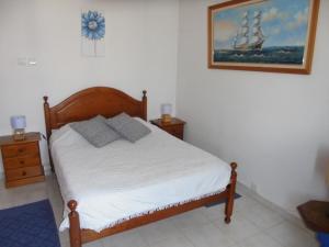 ラゴスにあるCasas da Barrocaのベッド付きのベッドルーム1室、壁に船の写真