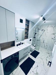 a white bathroom with a sink and a shower at Elite Apartment - Art of fine living in Cluj-Napoca +4 photos