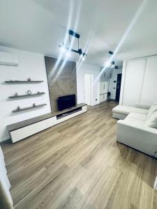 a living room with a white couch and a television at Elite Apartment - Art of fine living in Cluj-Napoca