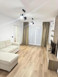 a living room with a white couch and a tv at Elite Apartment - Art of fine living in Cluj-Napoca