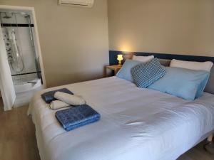 een bed met twee handdoeken erop met een douche bij Maison d'hôtes Beauregard in Donneville +13 foto's