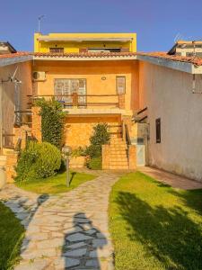 a house with a brick walkway in front of it at Casa Puni Porto Rotondo in Porto Rotondo