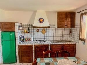 a kitchen with a stove and a green refrigerator at Casa Puni Porto Rotondo in Porto Rotondo