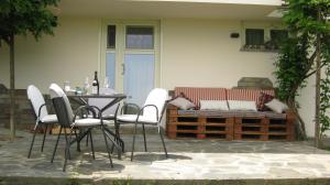 um pátio com uma mesa e cadeiras e um banco em Holiday Home Cannubi in Barolo em Barolo