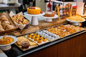 Un mostrador de panadería con diversos pasteles, tartas y pasteles. en Casa do Patio by Shiadu, en Lisboa