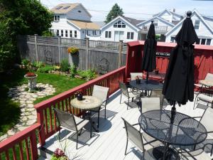 a patio with tables and chairs on a deck at Haven By The Sea B&B in Wells