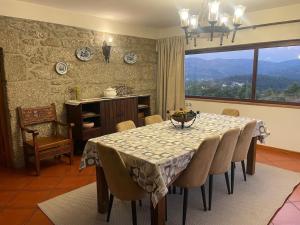 a dining room with a table and chairs and a window at Casa da Galheira in Vilela