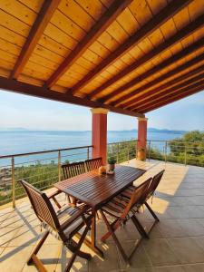 a wooden table and chairs on a deck with a view at Barbati Sunrise Suite in Barbati