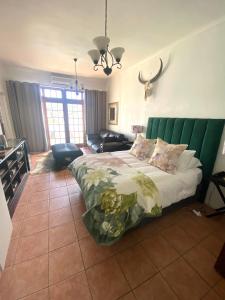 a bedroom with a large bed with a green headboard at Franschhoek- African dream in Franschhoek +16 photos