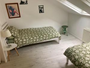 a bedroom with two beds and a table and a lamp at Warrenpoint Gate lodge in Warrenpoint