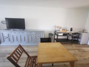 a living room with a wooden table and a tv at Casa della Lavanda in Sarnonico +8 photos