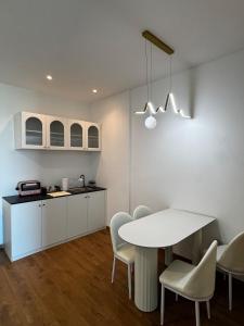 a kitchen and dining room with a white table and chairs at Summermall suits samarahan in Kota Samarahan