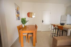une cuisine et une salle à manger avec une table et des chaises dans l'établissement Apto Beira-Mar com Vista, Churrasqueira e Piscina, à Mongaguá