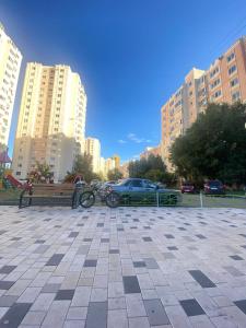 a bike parked next to a bench in a city at 2 комнатная квартира мкр Самал in Astana