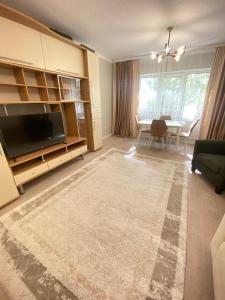 a living room with a television and a dining room at 2 комнатная квартира мкр Самал in Astana