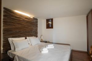 a bedroom with a white bed with two towels on it at Villa Stagiates in Stagiates