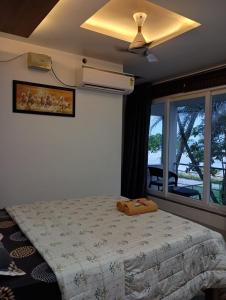 een slaapkamer met een bed en een plafondventilator bij Dolphin villa Beach Resort in Alleppey