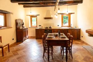 une cuisine avec une table et des chaises dans une pièce dans l'établissement Wild Adelasia - Cascina Sarvaglioni, à Ferrania