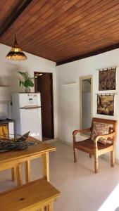 a living room with a table and a bench and a refrigerator at Aconchego em Barra Grande in Marau