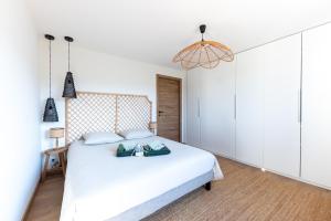 Un dormitorio con una cama blanca y una lámpara de araña. en NOUVEAU ! Maison de standing avec piscine et climatisation entre mer et montagnes, en Albitreccia 8 fotos más