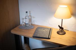 a table with a lamp and a book on a desk at Alma Hotel Oberstdorf in Oberstdorf