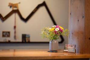 a vase filled with flowers sitting on a table at Alma Hotel Oberstdorf in Oberstdorf