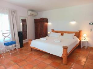 a bedroom with a large white bed in a room at Villa 8br, Sea Views, Walk To The Beach, Pool in Santa Eularia des Riu