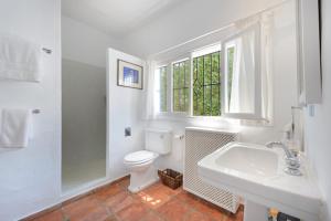 a bathroom with a toilet and a sink and a window at Villa 8br, Sea Views, Walk To The Beach, Pool in Santa Eularia des Riu +41 photos