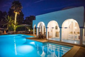 a villa with a swimming pool at night at Villa 8br, Sea Views, Walk To The Beach, Pool in Santa Eularia des Riu