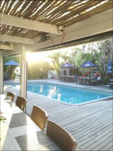 una piscina con terrazza con tavolo e sedie di Genesis Cape St Francis resort a Cape St Francis