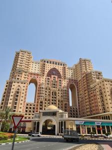 a large building with many windows on a street at Lovely Studio with balcony in Silicon Oasis in Dubai