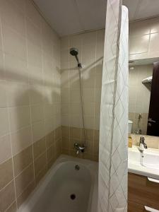 a bathroom with a bath tub and a sink at Lovely Studio with balcony in Silicon Oasis in Dubai