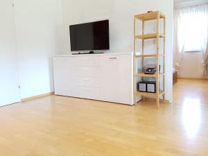 a living room with a tv on a white dresser at Reschbergerhof Appartements by Geierspichler in Anif