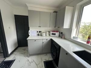 サウサンプトンにあるSouthampton Cruise Park & Stay Houseの白いキャビネットと白いカウンタートップを備えたキッチン +16枚の写真