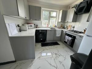 サウサンプトンにあるSouthampton Cruise Park & Stay Houseのキッチン(白いキャビネット、洗濯機、乾燥機付)