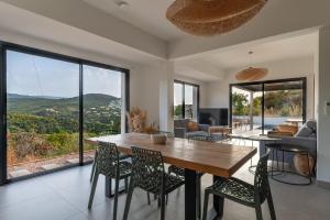 Una sala de estar con una mesa y sillas de madera. en NOUVEAU ! Maison de standing avec piscine et climatisation entre mer et montagnes, en Albitreccia