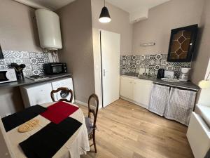 a small kitchen with a table in a room at Studio du centre - L'Artdu'Net - in Charleville-Mézières