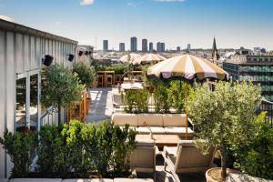 a rooftop patio with tables and umbrellas on a building at NH Copenhagen Grand Joanne in Copenhagen