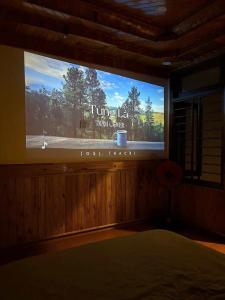 a large television screen in a room with a bed at An Nam HomeStay1 in Thôn Trường Giang
