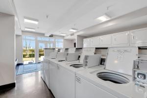 a large white laundry room with white washers and dryers at Downtown Nashville River Views Pool Parking in Nashville