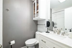a white bathroom with a toilet and a sink at Downtown Nashville River Views Pool Parking in Nashville +12 photos