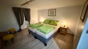 a bedroom with a bed with two green pillows at Camping Mitrov in Strážek