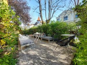 a patio with chairs and tables in a garden at Bella Veselova in Ljubljana