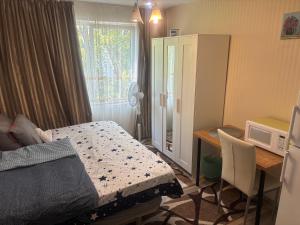 a bedroom with a bed and a desk with a microwave at A Good Vibe in M. Ciurel