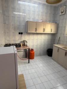 a kitchen with white cabinets and a red hose at قصر الضيافه in Al Madinah