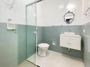 une salle de bain avec toilettes et douche en verre dans l'établissement 2 suítes Lareira Jacuzzi Churrasqueira, à Campos do Jordão 40 autres photos