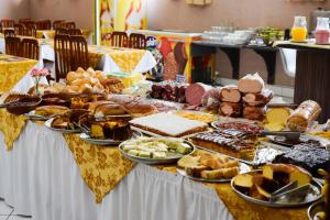 a table filled with different types of bread and pastries at Estoril Palace Hotel in Registro