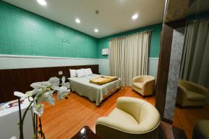 een hotelkamer met een bed en een stoel bij Estoril Palace Hotel in Registro